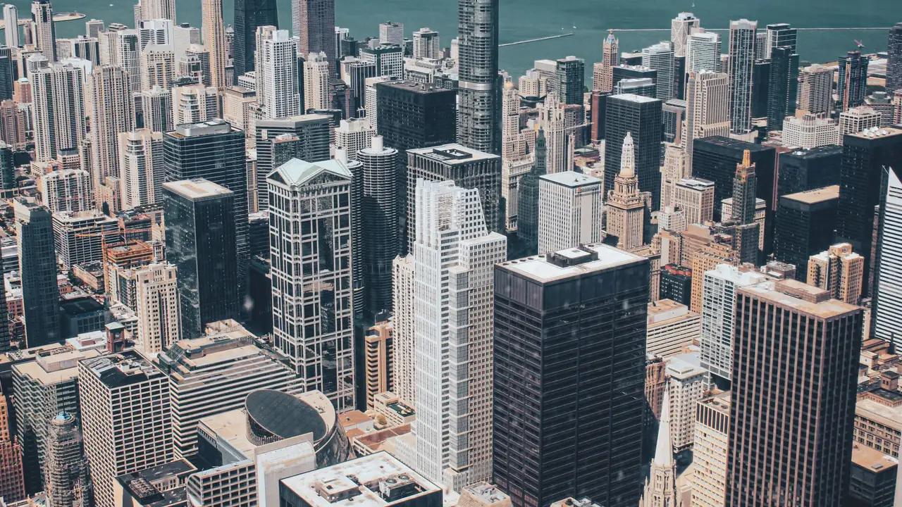 Aerial view of the Chicago skyline of glass office towers at blue hour with Lake Michigan on the horizon